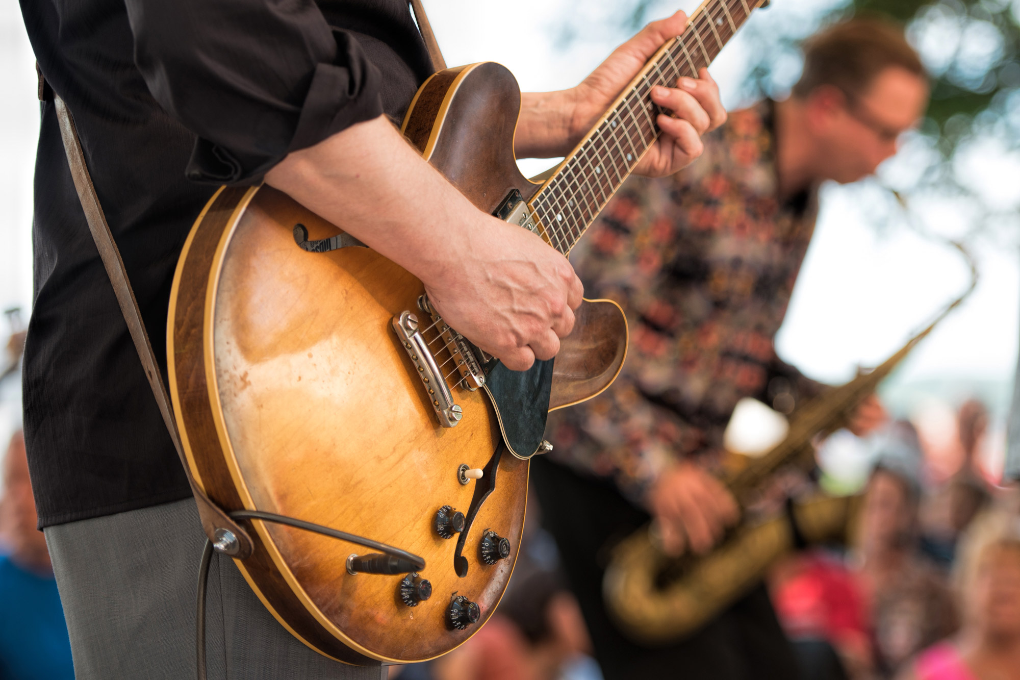 Mitglieder einer Band spielen E-Gitarre und Saxophon