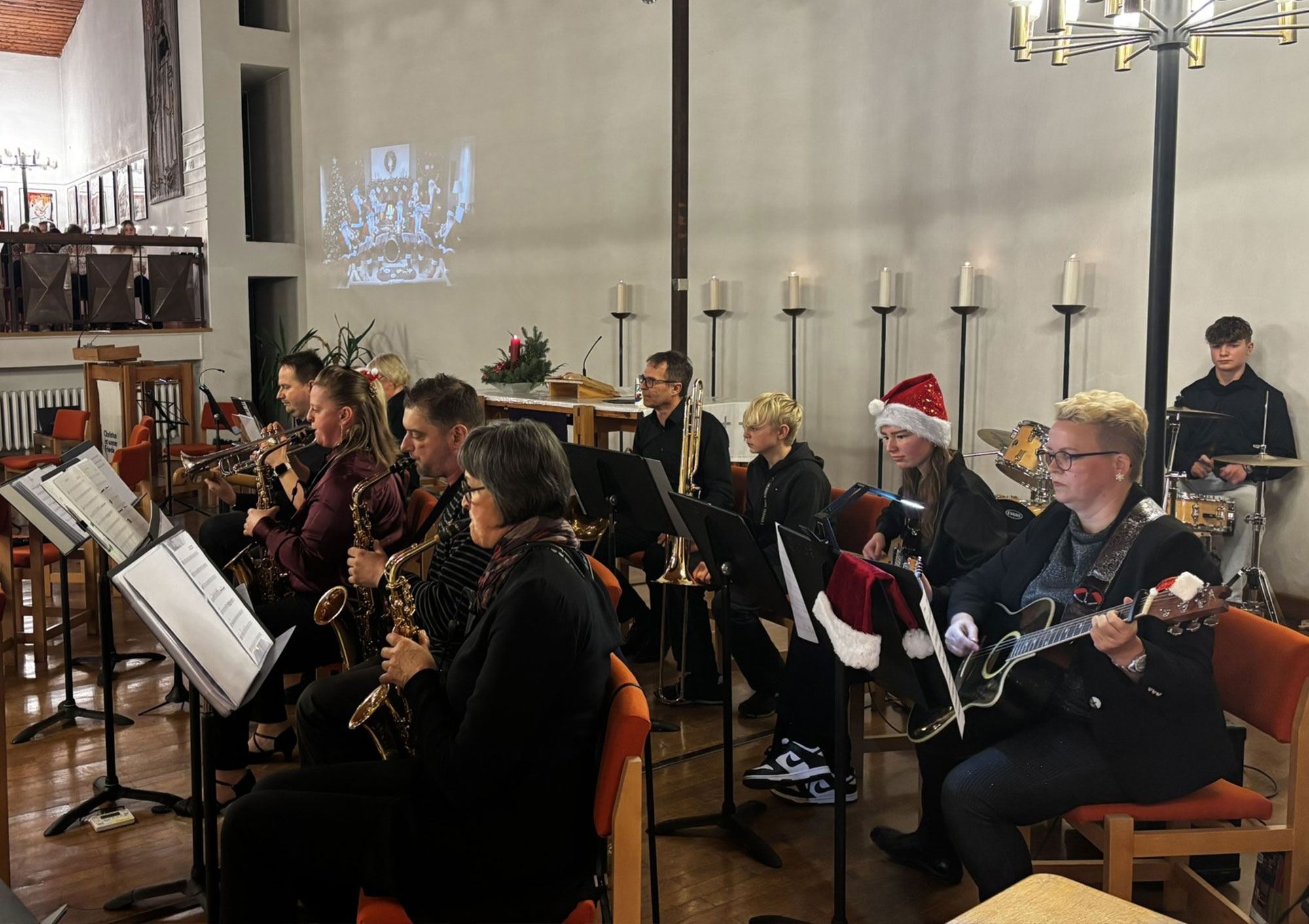 Musikerinnen und Musiker der Big Band mit ihren Instrumenten und Weihnachtsmützen