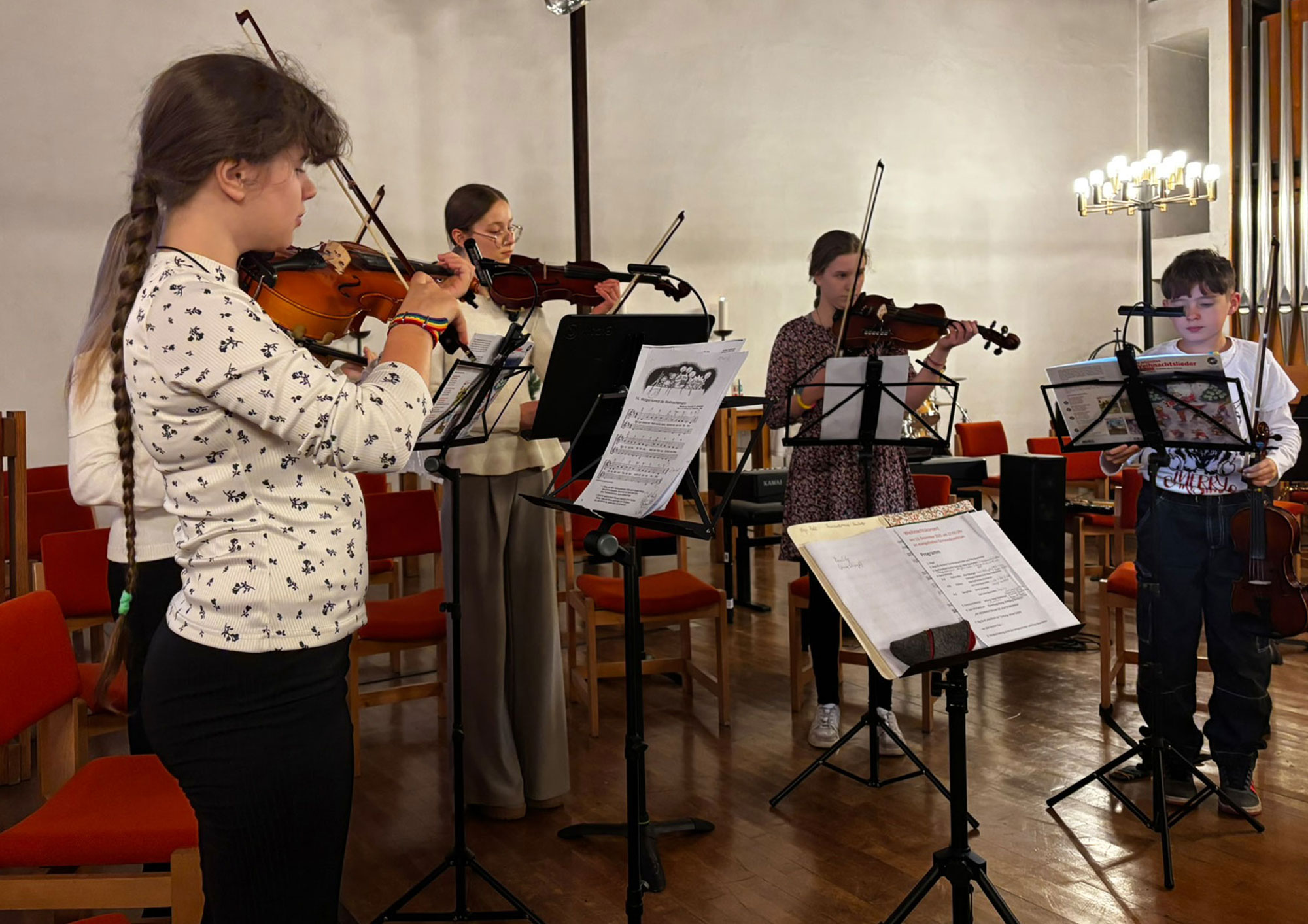 5 Jugendliche stehen im Halbkreis und spielen Geige